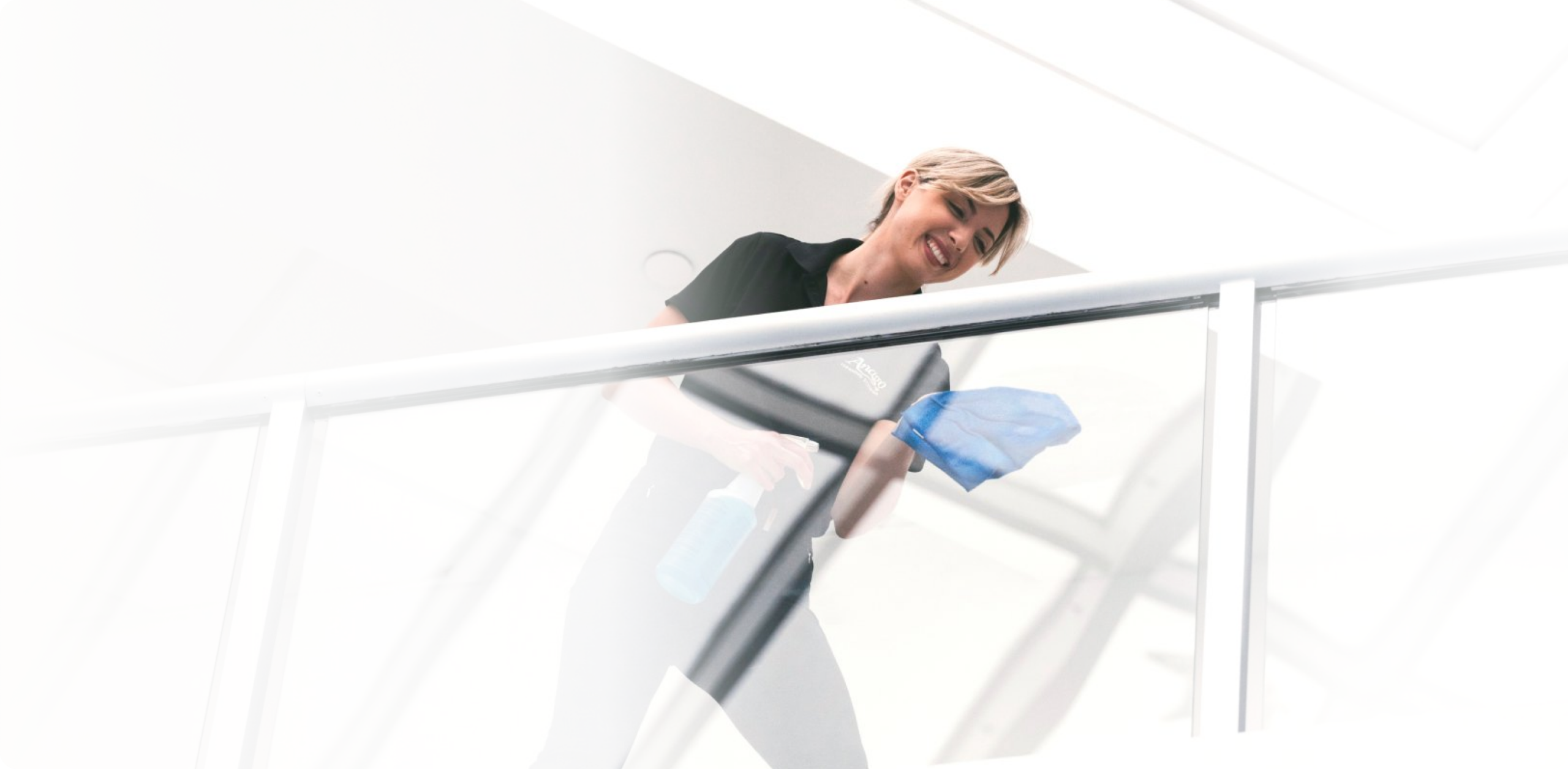 Anago cleaning professional wiping a glass stair railing